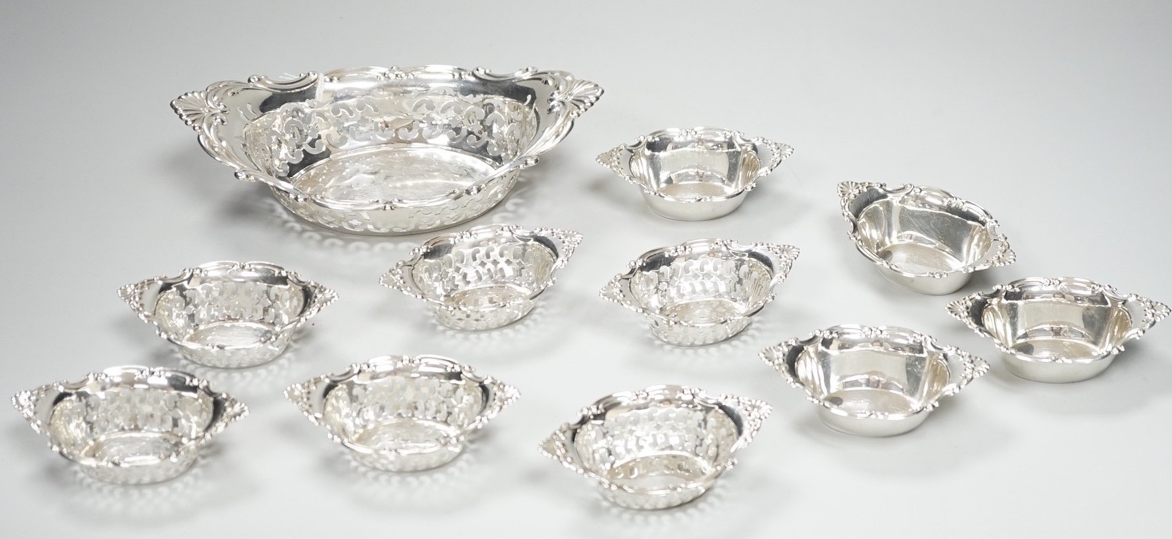 A set of ten Canadian Birks pierced sterling nut dishes, 97mm and a similar larger dish, 20.8cm, 11oz.